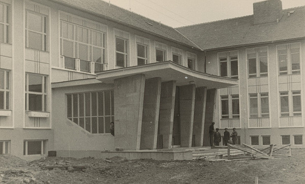 Vladimír Dedeček – Bližšie neznáma základná škola (50.te roky). Detailný pohľad na vstupnú fasádu vo výstavbe.
